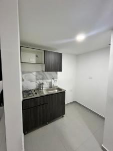 a small kitchen with a sink and a stove at Apartamento moderno, central, inteligente y totalmente equipado in Duitama