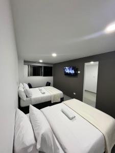 a room with two beds and a flat screen tv at Apartamento moderno, central, inteligente y totalmente equipado in Duitama