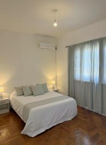 a white bedroom with a large bed and a window at The Marseille Oasis in La Porteña +9 photos