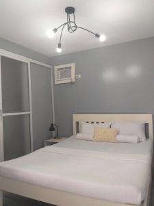 a bedroom with a large white bed in a room at Angel's Bed and Breakfast Sipalay in Sipalay