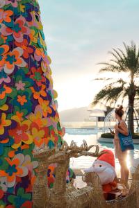 a woman standing in front of a colorful building at HUALUXE Sanya Yalong Bay Resort in Sanya