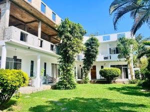 an exterior view of a white house with trees at Lost Paradise Sri Lanka in Mirissa