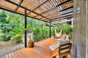 a patio with a wooden deck with a pergola at Salt n Pepper - Rosemary Villa with shared Pool - Adults Only in Puerto Viejo