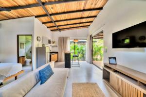 a living room with a couch and a tv at Salt n Pepper - Rosemary Villa with shared Pool - Adults Only in Puerto Viejo
