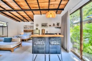 a kitchen and living room with a table and chairs at Salt n Pepper - Rosemary Villa with shared Pool - Adults Only in Puerto Viejo