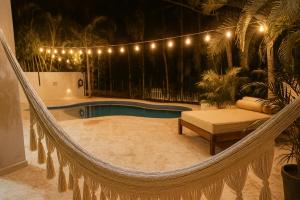 a hammock with a bench and a swimming pool at 7BR Private Jacuzzi & Pool Villa Sleeps 16 Walk to Beach Lagoon and Golf in Puerto Aventuras