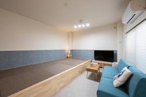 a living room with a couch and a flat screen tv at NAGI setouchi in Takamatsu