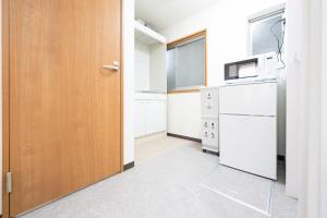 a kitchen with a white refrigerator and a wooden door at NAGI setouchi in Takamatsu +42 photos