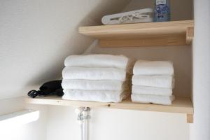 a stack of towels on a shelf in a bathroom at NAGI setouchi in Takamatsu