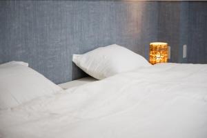 a white bed with two pillows and a lamp at NAGI setouchi in Takamatsu