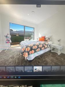 Una pantalla de televisión que muestra un dormitorio con una cama. en Airport Heaven Comfort Home, en Auckland