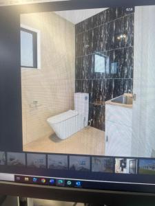 Una pantalla de computadora de un baño con inodoro. en Airport Heaven Comfort Home, en Auckland