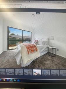 Una pantalla de computadora que muestra un dormitorio con una cama. en Airport Heaven Comfort Home, en Auckland