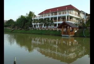 a large building on the side of a river at Rayong Phurua Resort ระยองภูเรือรีสอร์ท in Phu Ruea