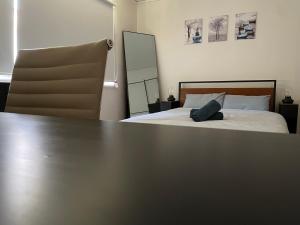 Un dormitorio con una cama y una mesa grande. en Marsfield-Queen-MacUni-MacCentre-Bus-Woolworth, en Sídney