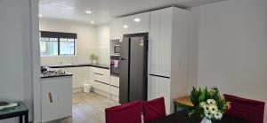 a kitchen with a black refrigerator in a room at Baden Lodge Motel - PRIVATE SPA Bath in Rotorua