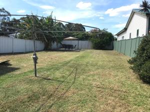 een tuin met een parkeermeter in het gras bij Relaxing Vintage Cottage in Corrimal +1 foto