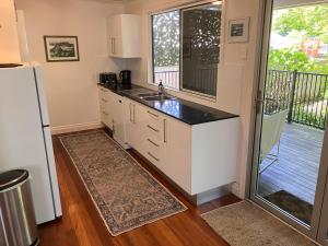 ブリスベンにあるFamily and pet friendly home in Brisbaneのシンクと冷蔵庫付きのキッチン