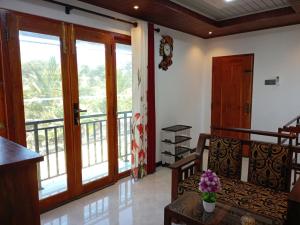 a living room with a couch and a balcony at Wadula Resort in Nochchiyagama