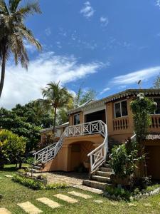a house with a staircase leading up to a garage at Holiday Beach Hotel in Nosy Be