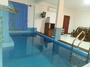 a bathroom with a swimming pool with blue tile floors at Wadula Resort in Nochchiyagama