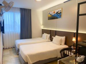 a hotel room with two beds and a table at A25 Premium Hotel - 12 Ngô Sỹ Liên in Hanoi