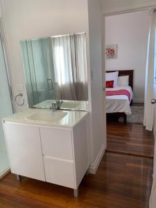 ブリスベンにあるFamily and pet friendly home in Brisbaneの洗面台と鏡のある白いバスルーム