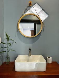 a bathroom with a white sink and a mirror at Monkey Republic Kampot in Kampot