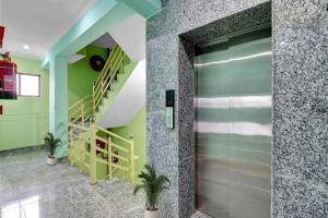 a glass door in a room with a staircase at Super Collection O The Kailash Hotel in Dehradun