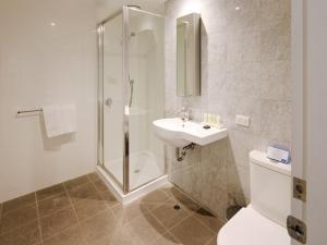 a bathroom with a shower and a sink and a toilet at Richmond Central Apartments in Melbourne