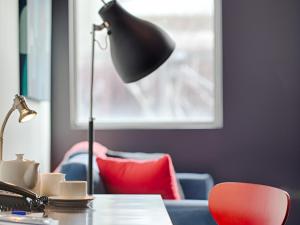 a desk with a lamp and a red chair at Richmond Central Apartments in Melbourne