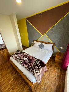 a bedroom with a bed in a room with yellow walls at Ooty Dream Weaver cottage in Ooty