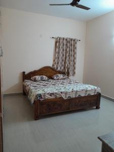 a bedroom with a wooden bed in a room at RKGroupStays in Tirupati