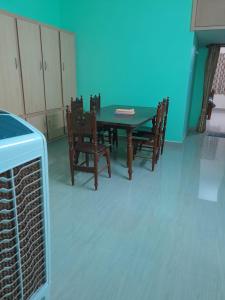 a dining room with a table and chairs and a blue wall at RKGroupStays in Tirupati