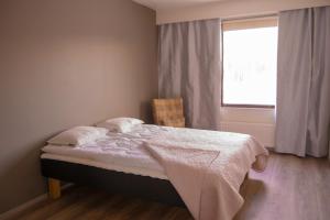 a bedroom with a bed with a window and a chair at Apartment 55m2 in Kemijärvi 