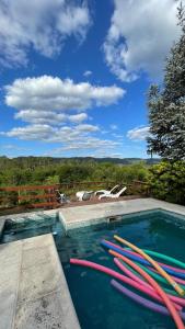 a swimming pool with a bunch of water hoses at Cabañas Ojos de Cielo in Santa Rosa de Calamuchita