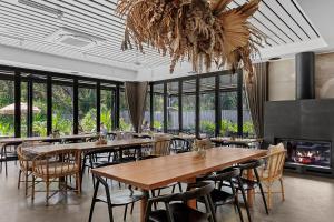 Privately Managed Golf View - Bangalay Villas في Shoalhaven Heads: مطعم مع طاولات وكراسي ومدفأة