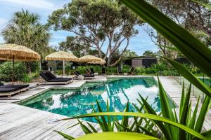 Privately Managed Golf View - Bangalay Villas في Shoalhaven Heads: حمام سباحة خارجي مع كراسي ومظلات