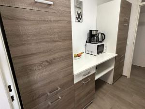 eine Küche mit weißer Arbeitsplatte und Mikrowelle in der Unterkunft Modernes Apartment mit Balkon in Marl