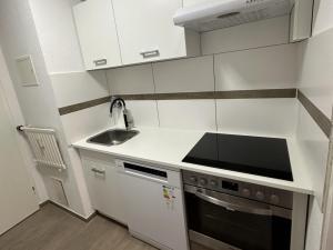 eine weiße Küche mit Spüle und Herd in der Unterkunft Modernes Apartment mit Balkon in Marl + 5 Fotos