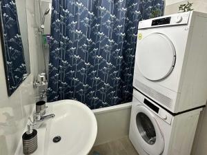 ein Badezimmer mit Waschbecken und Waschmaschine in der Unterkunft Modernes Apartment mit Balkon in Marl