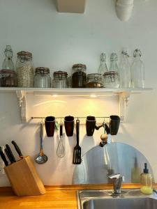 a kitchen with a sink and utensils on a shelf at Idyllic Country House Overlooking Svanninge Hills in Millinge +32 photos