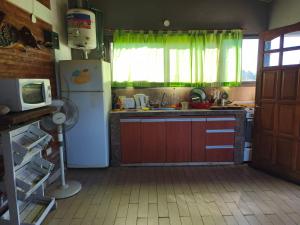 a kitchen with a refrigerator and a sink and a microwave at Cabañas Ojos de Cielo in Santa Rosa de Calamuchita