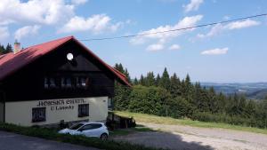 un coche aparcado frente a un edificio en Horská chata "U Lanovky" en Zadov