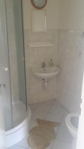 y baño blanco con lavabo y ducha. en Horská chata "U Lanovky" en Zadov