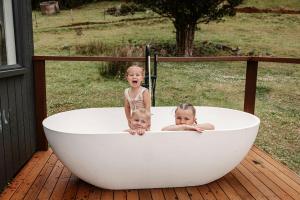 twee kinderen in een badkuip op een terras bij Tiny Oscar in Robertson