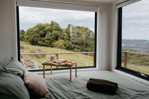a bedroom with a bed and a large window at Tiny Oscar in Robertson