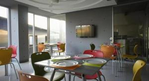 Ban Na KhwaiA+ Hotel的一间配备有桌子和五颜六色椅子的用餐室