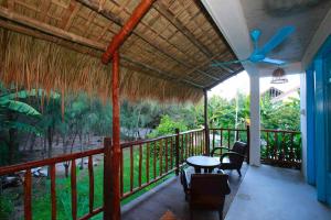 porche con mesa, sillas y ventilador de techo en Life Beach Villa, en Hoi An