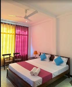 a bedroom with a large bed with blue pillows at Secret Hill Haven in Unawatuna